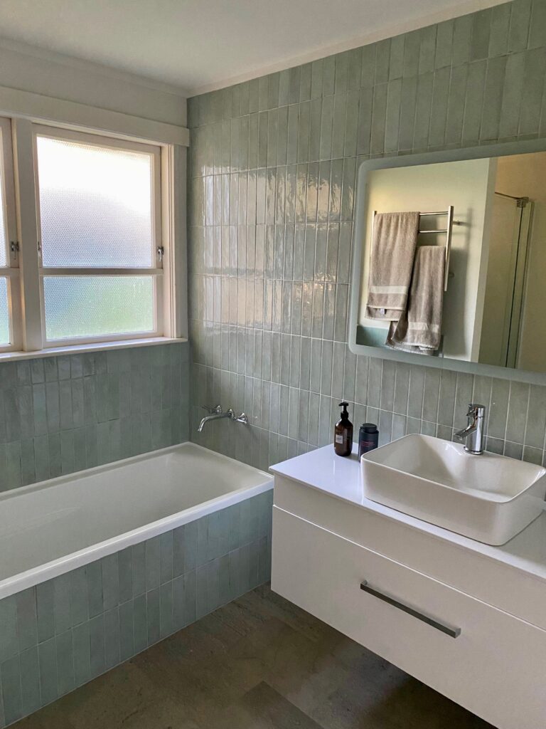 Modern bathroom with fitted bathtub, wall-mounted tap and contemporary vanity unit, installed by Gloucestershire plumber, J. Annear Plumbing & Heating.
