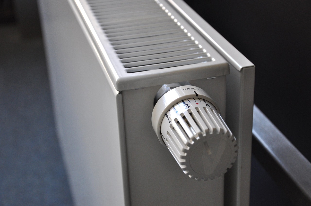 Close-up of a radiator with a thermostatic valve used in home heating systems.